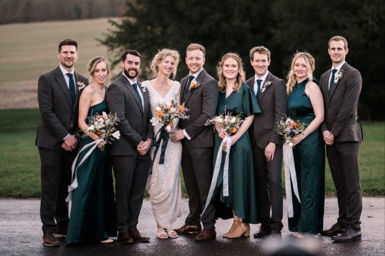 Group shot of wedding party with  whites and forest green dresses.