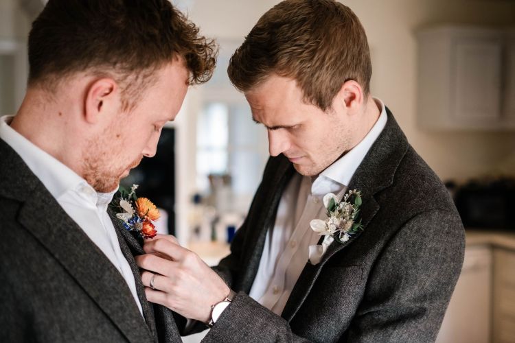 Groom having his buttonhole pinned on