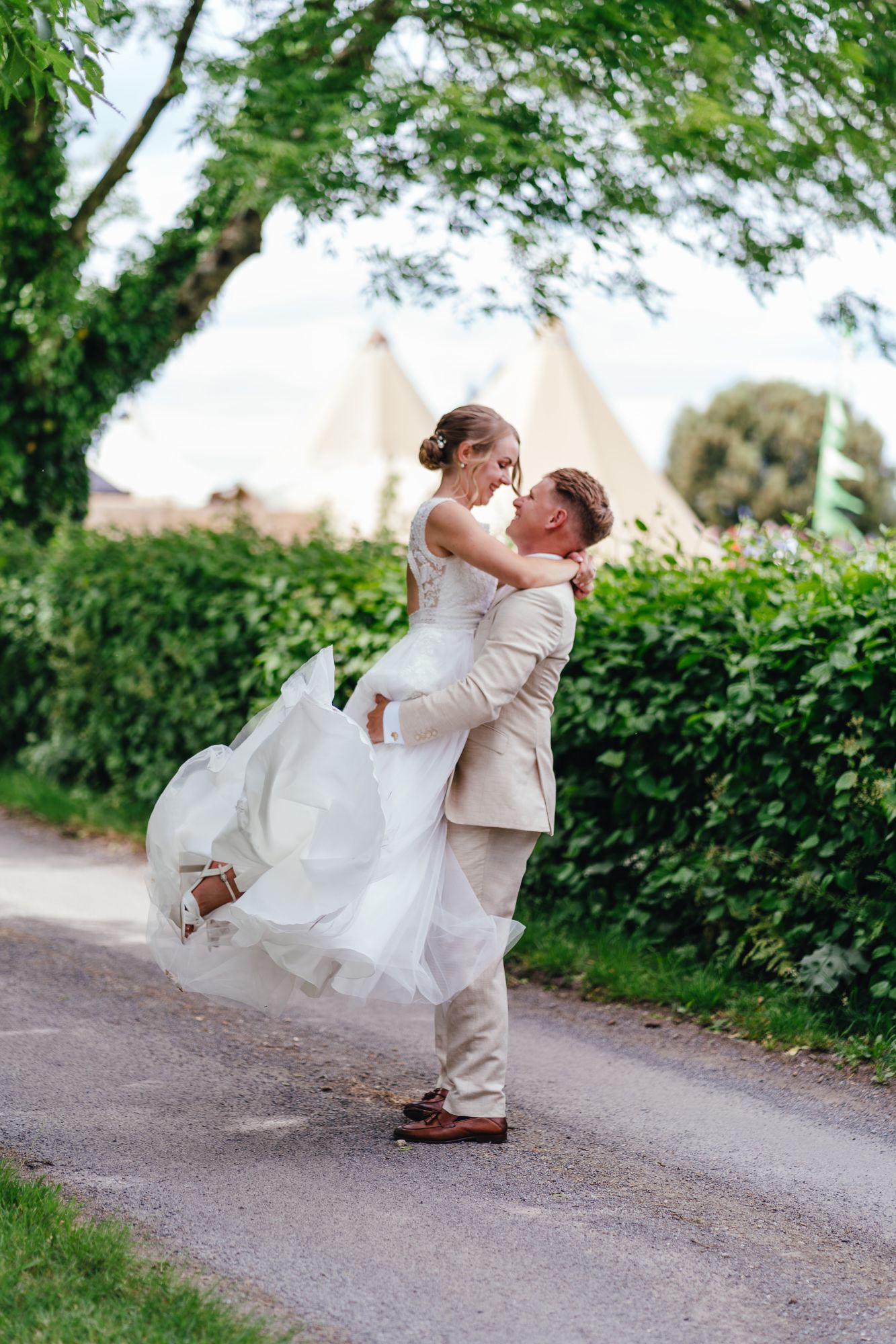 Wedding couple, just married, dancing at Pennard Hill Farm with tipi's in the background