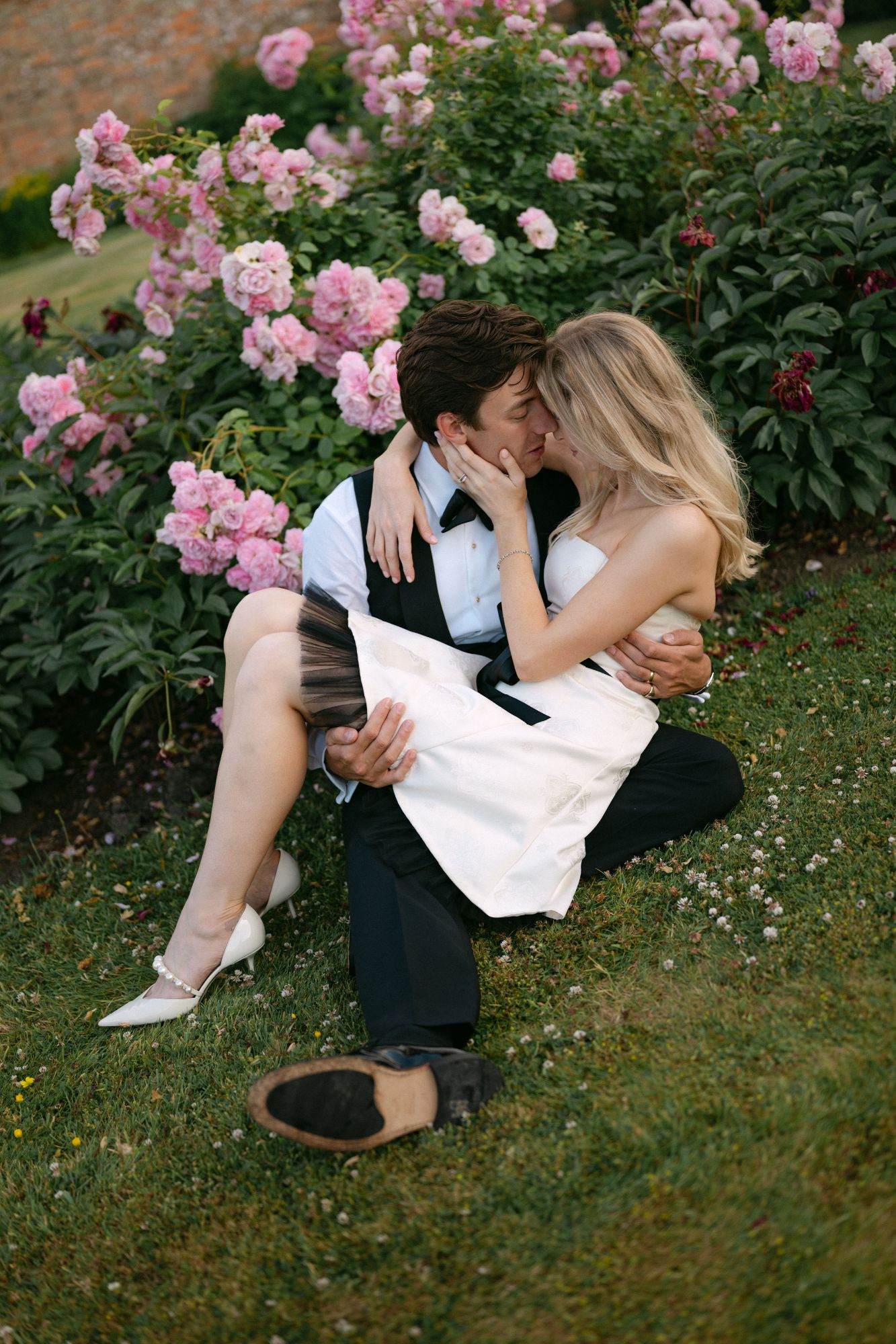 Couples kissing in the roses at North Cadbury Court, on their wedding day. Photo: Sophia Veres