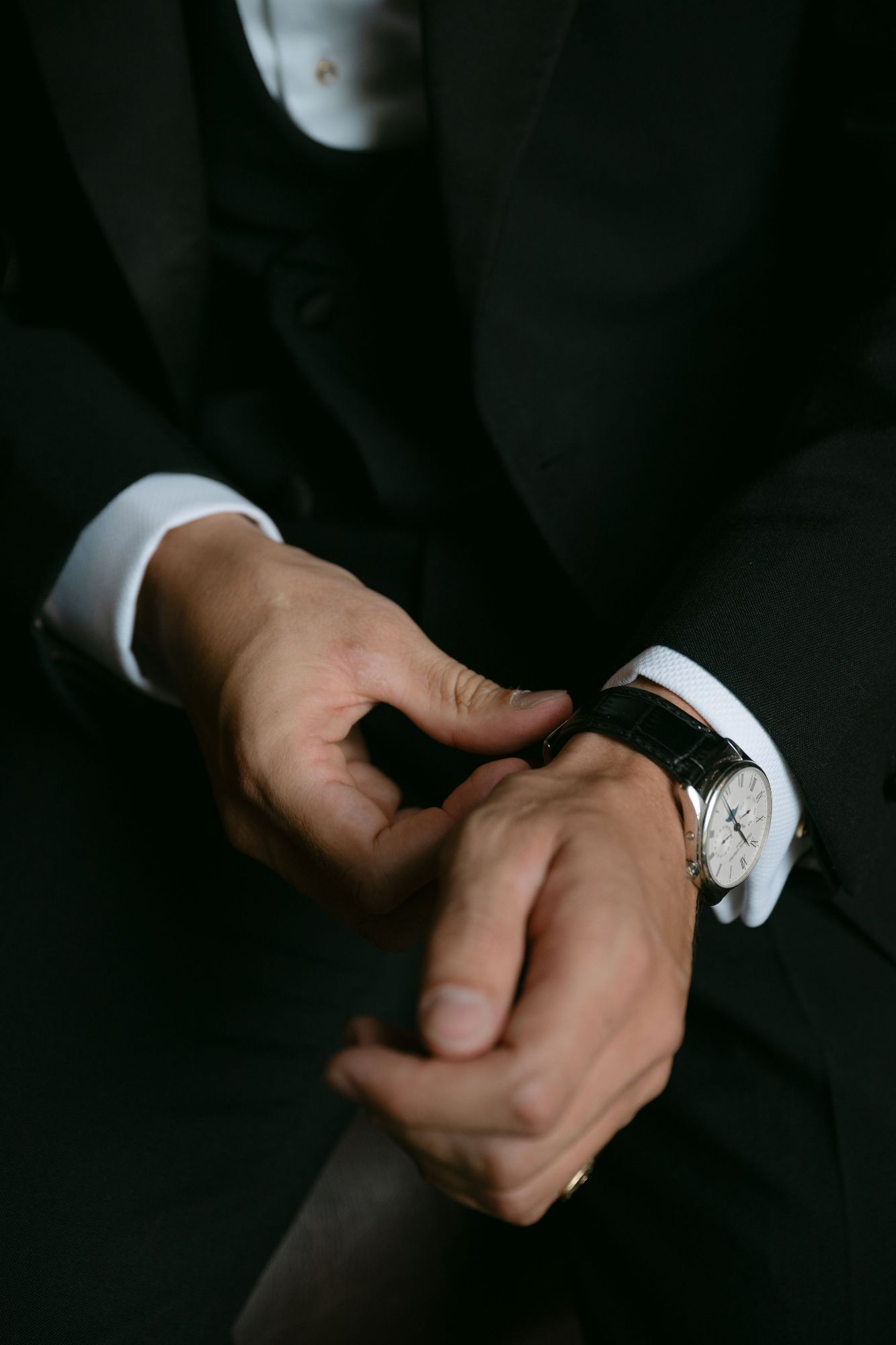 Groom adjusting his watch on his wedding day at North Cadbury Court