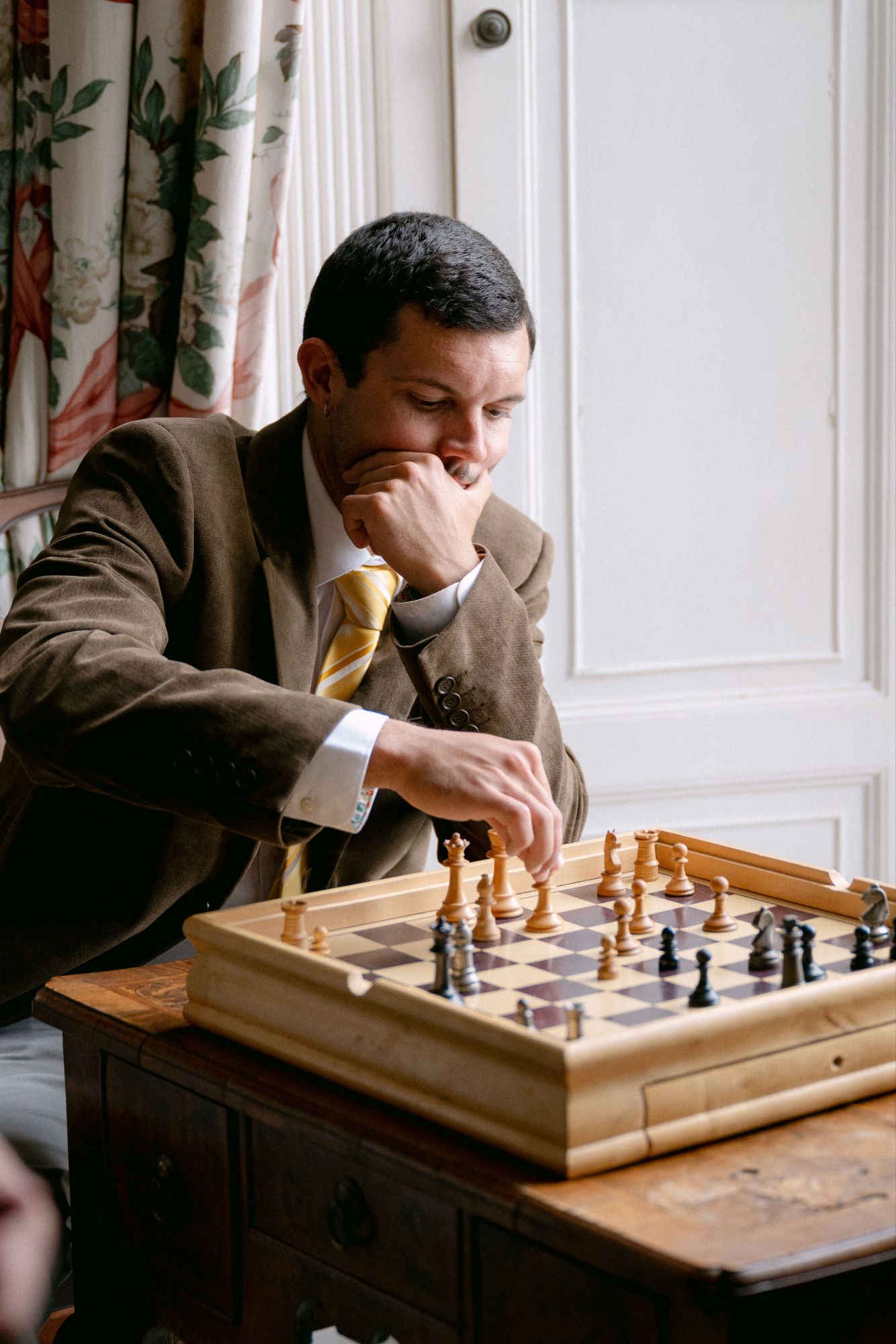 Wedding guest playing a game of chess during the drinks reception at North Cadbury Court, phot: Sophia Veres