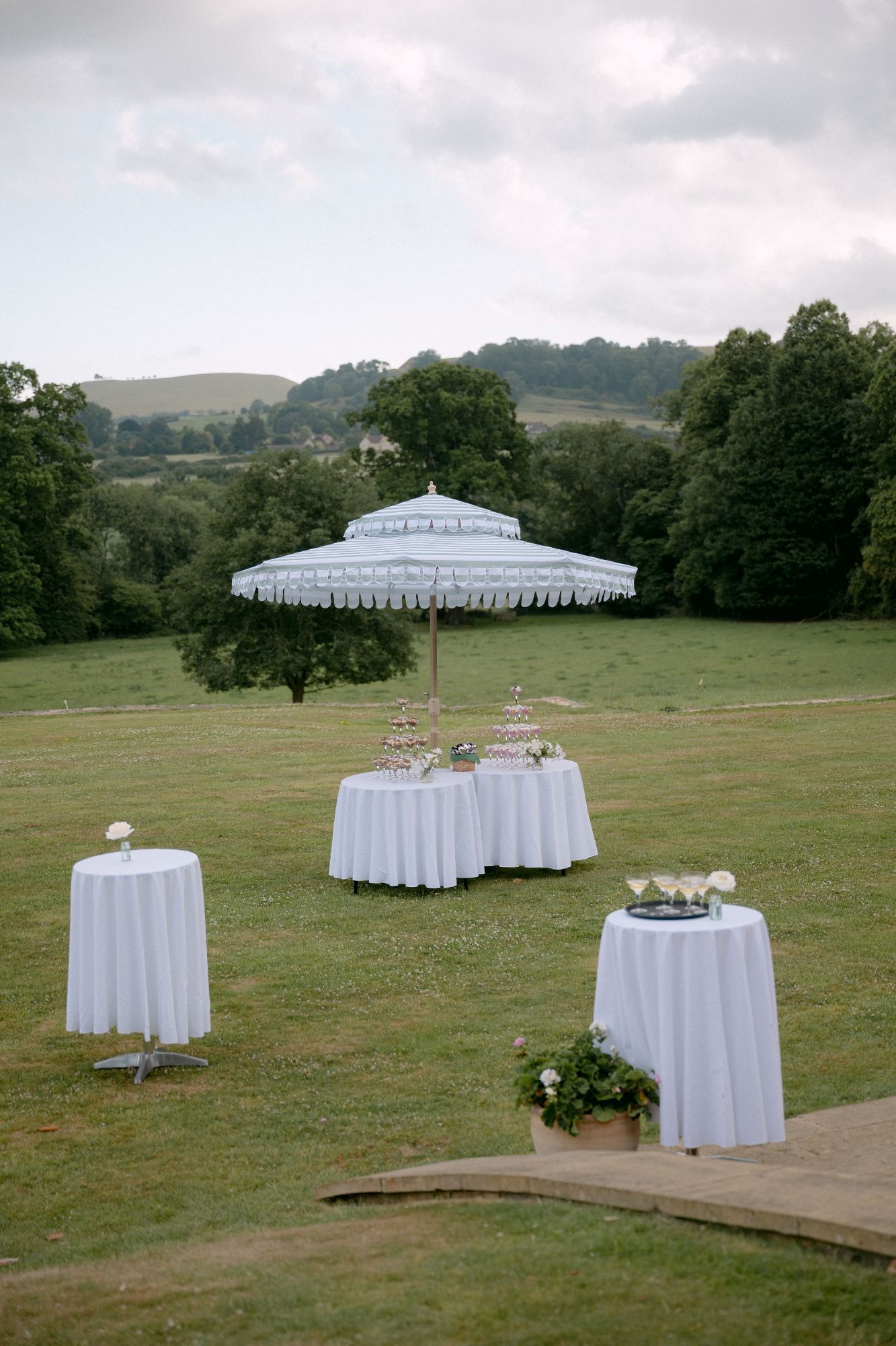 Beautiful outdoor table set up with large luxury parasol, at North Cadbury Court, with cake tables. Photo: Sophia Veres